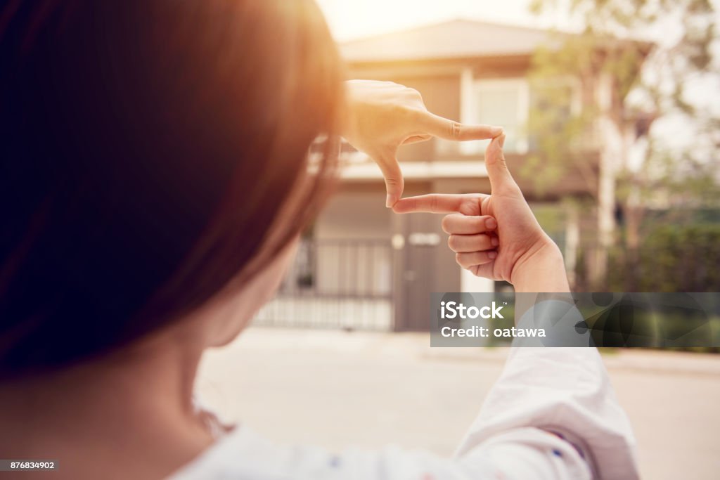 Hands of woman making frame gesture with home background. Planning for the future resident concept. Exploration Stock Photo