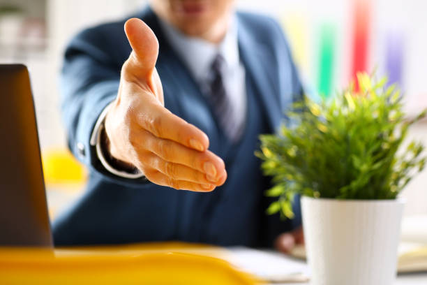 istock Man in suit and tie give hand as hello in office 876838100