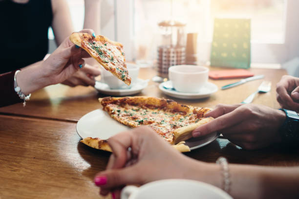 image du gros plan d’amis partageant une pizza italienne traditionnelle et boire du thé dans un café - healthy eating italian culture traditional culture close up photos et images de collection