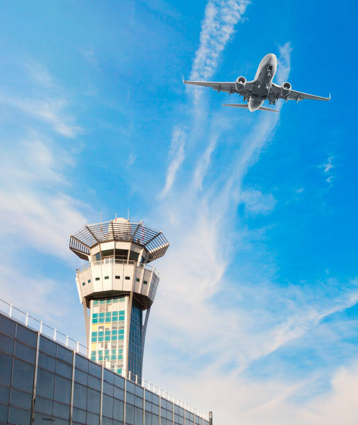 istock Airplane flying and air traffic control tower 876848938