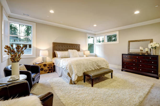 istock Beige and brown master bedroom boasts tufted queen bed 876854624