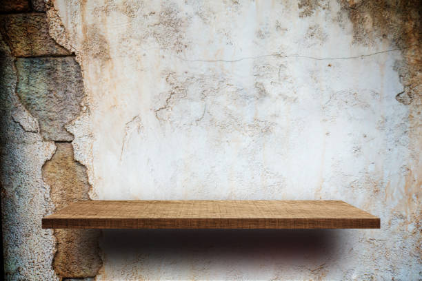 istock Empty wooden shelves display on cracked brick wall 876855008