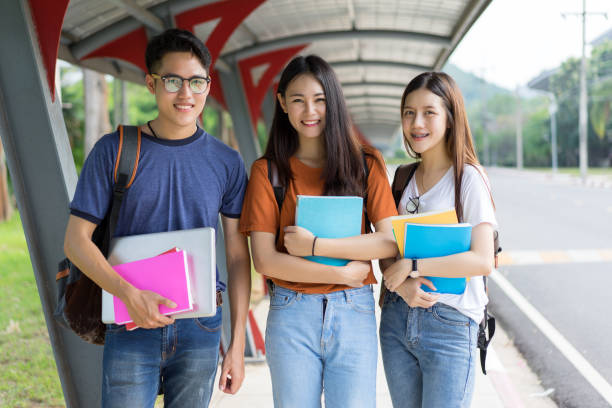 istock Students asian portrait together smiling group reading book study with laptop at university high school campus,college in summer holiday relaxation 876865080