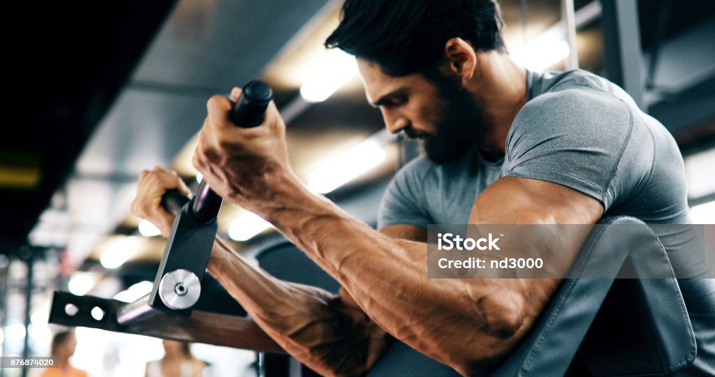 Jeune homme beau faire des exercices dans la salle de gym - Photo de Salle de gym libre de droits