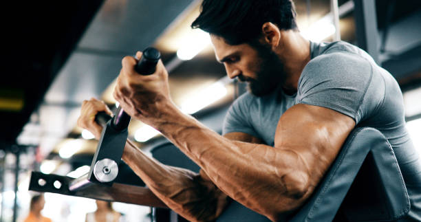 young handsome man doing exercises in gym - bicep imagens e fotografias de stock