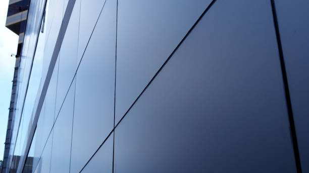istock Close up perspective big square grey tile wall of modern building 876874236