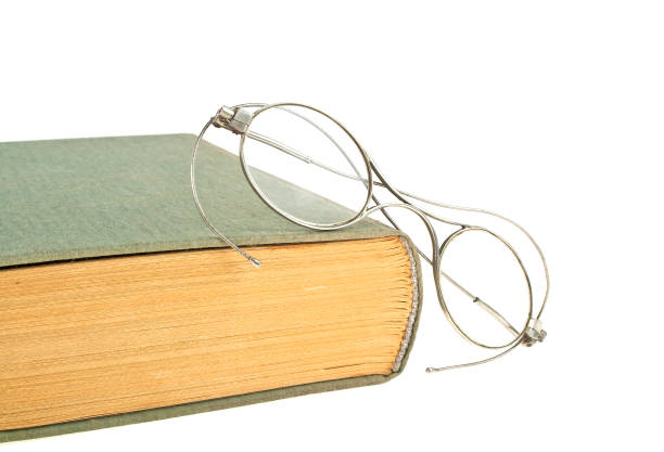 istock Old book and old glasses isolated on white background 876877360