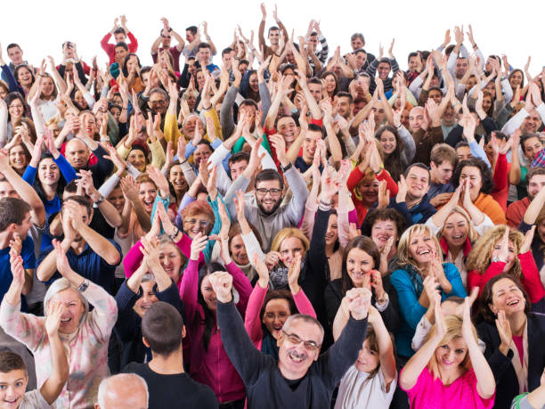 Large group of cheerful people having fun while applauding.