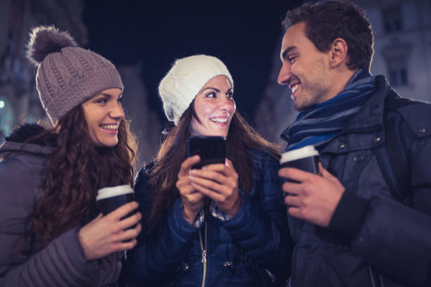 istock Young people having fun outdoors, watching social media posts on smart phone 876883704