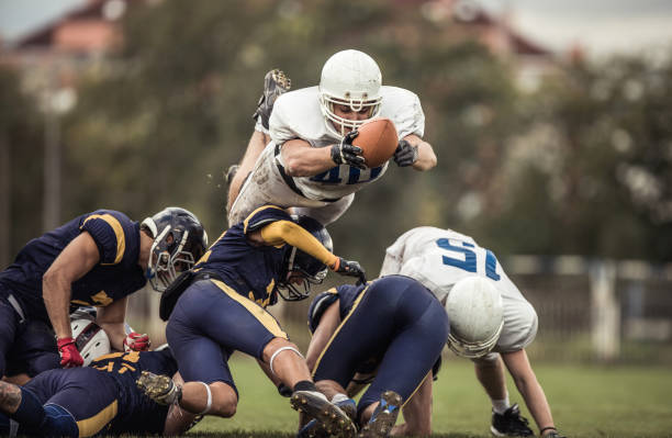 zdeterminowany amerykański piłkarz z piłką próbuje zdobyć przyłożenie. - running back zdjęcia i obrazy z banku zdjęć