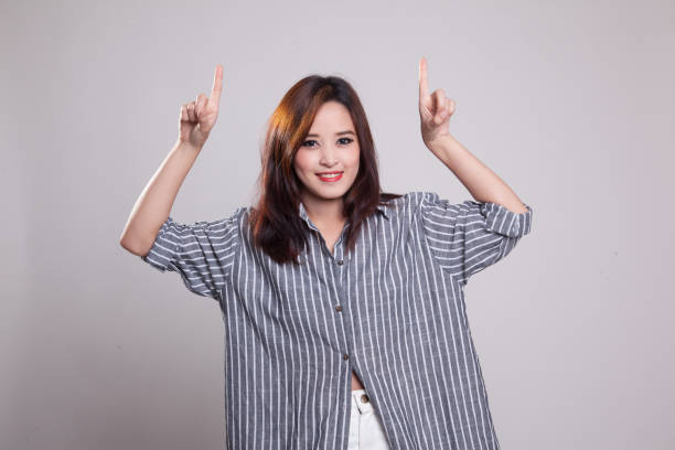 istock Young Asian woman point to blank space. 876890060