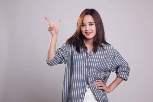 istock Young Asian woman smile and point. 876890218