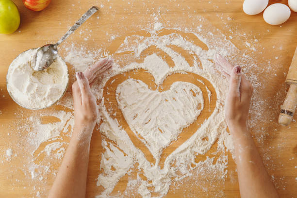 istock Hand drawn heart in flour on the kitchen table and other ingredients. Top view. 876890588