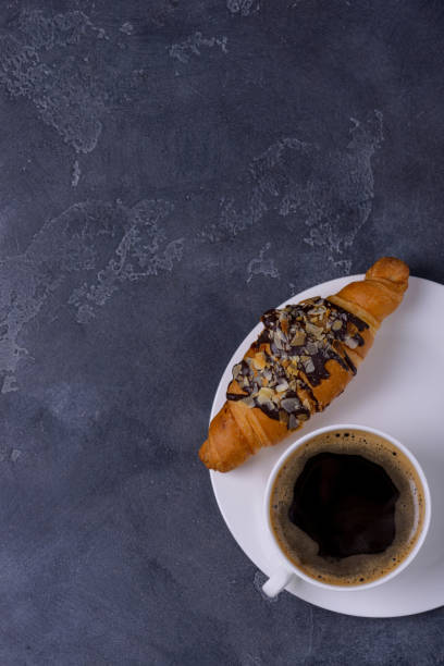istock Fresh croissant and coffee cup on stone table 876891130