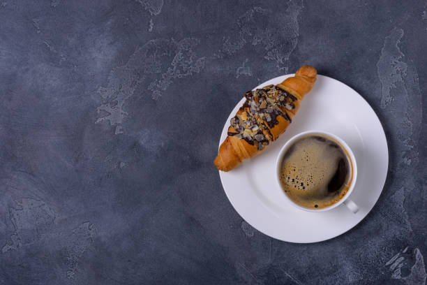 istock Coffee and croissant on stone background 876891300