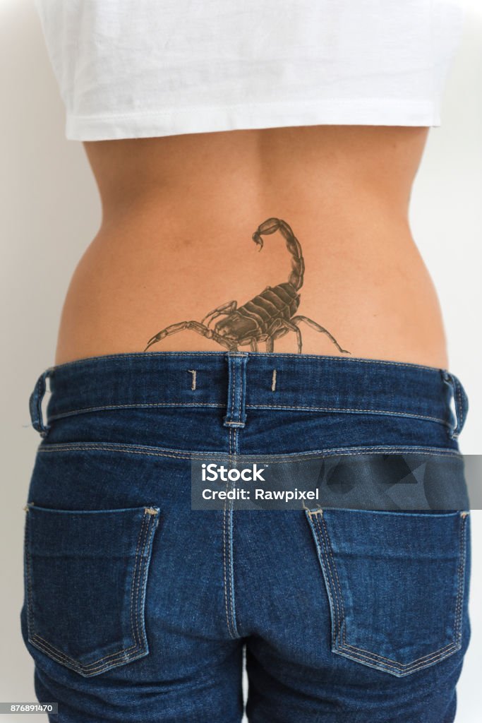 A Woman Is Showing Her Tattoo On Her Hips Stock Photo - Download Image Now  - Tattoo, Scorpion, Back - iStock
