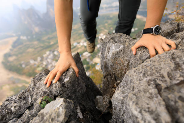 istock brave woman backpacker climbing rock to the  mountain top 876895182
