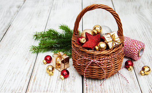 Christmas baubles in basket on wooden table