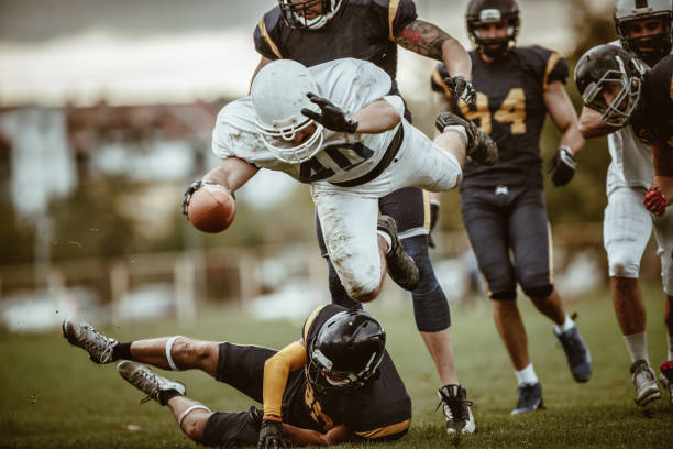 istock American football quarterback passing through defense for a touchdown. 876895934