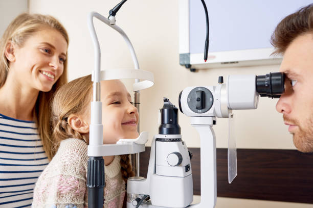 little girl testing sight - eye exam child optometrist human eye imagens e fotografias de stock
