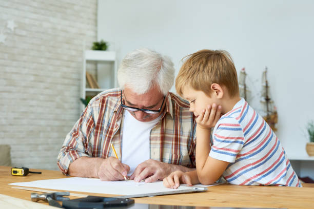 istock Grandfather and Little Boy Drawing Together 876900304