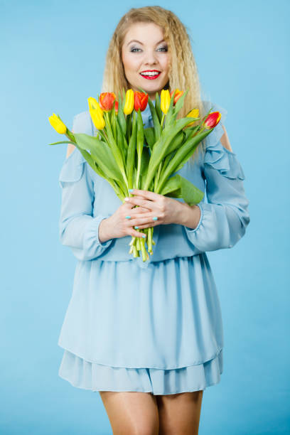 istock Pretty woman with red yellow tulips bunch 876903418