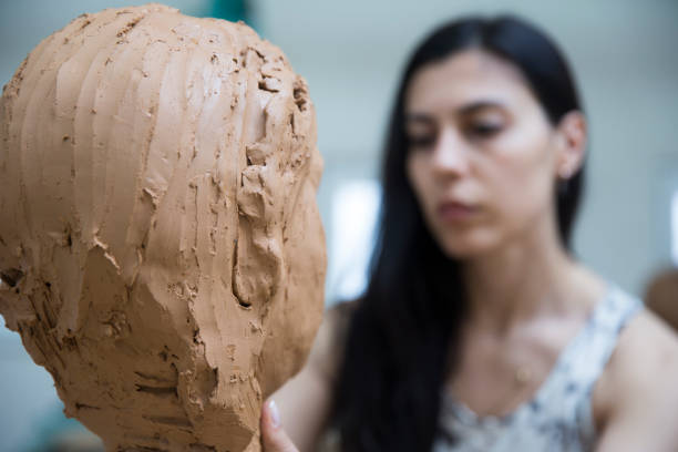 istock Artist working on clay sculpture in art studio 876907224