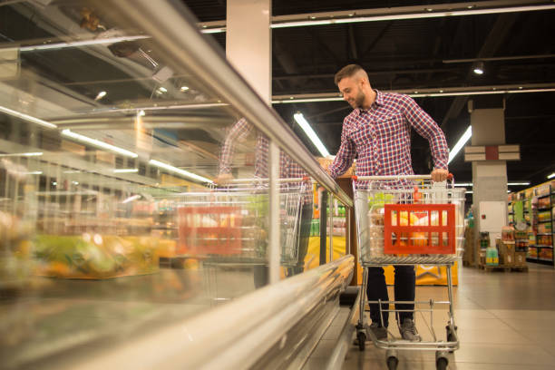 istock Handsome Man Choosing Food in Supermarket 876907486
