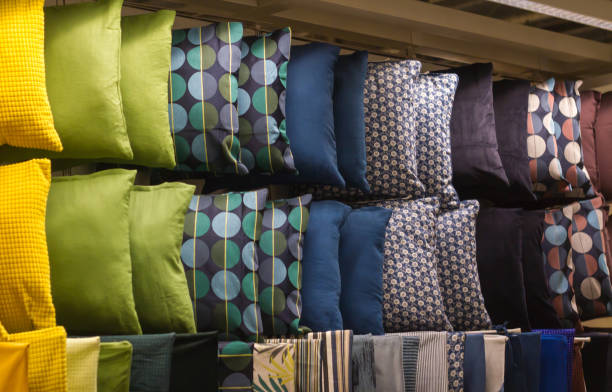 многие образцы яркого цвета подушки висит на полке в магазине - bedding merchandise market textile стоковые фото и изображения