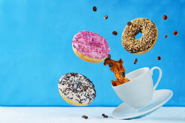 istock Flying multicolored donuts and a cup of coffee 876910030