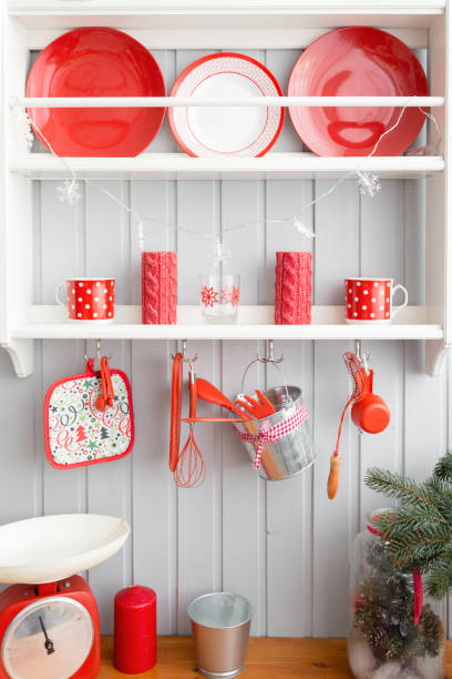 istock shelves with dishes. Interior light grey kitchen and red christmas decor. Preparing lunch at home on the kitchen concept. 876914474