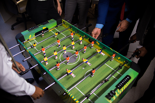 High angle view of unrecognizable office workers playing table football on party