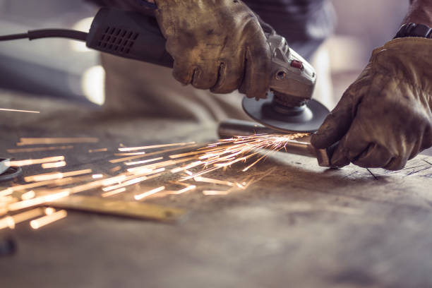 onherkenbaar arbeider snijden ijzer met een zaag aan een workshop. - elektrische zaag stockfoto's en -beelden