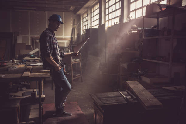 istock Full length of male worker examining business plan in a workshop. 876920278
