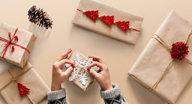 istock Woman's hands wrapping christmas holiday present with craft twin 876923278