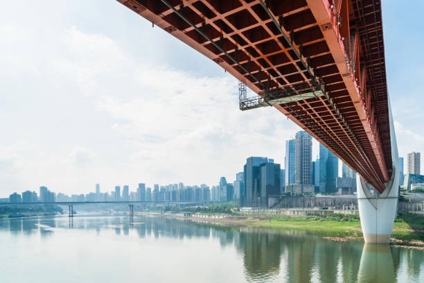 istock suspension bridge over river in modern city 876924270