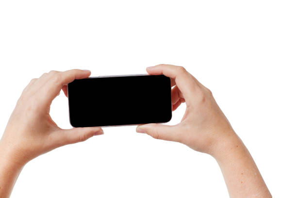 A woman's hands hold up a cellphone, taking a photograph. The screen is blank and can be used as copy space.