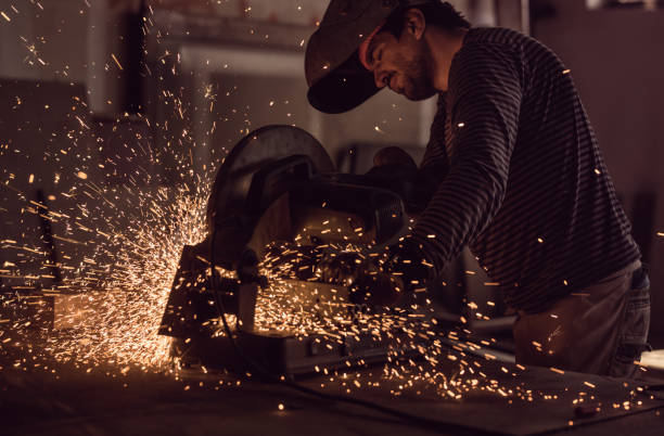 istock Manual worker working in a factory while welding an iron with electric saw. 876926704