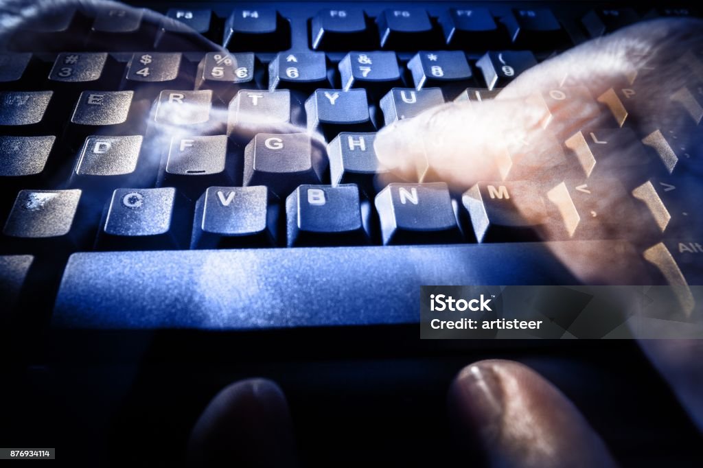 Computer keyboard. Keyboard with blurred hands typing on it - fast typing concept or ghost writing concept Adult Stock Photo