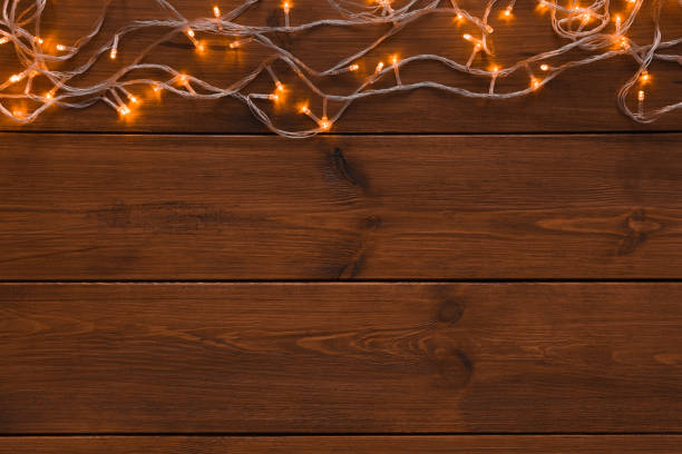 istock Christmas lights border on wood background 876934248