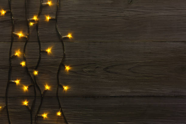 istock Christmas lights border on grey wooden background 876934472