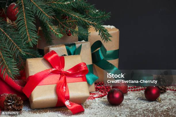 Weihnachten Urlaub Hintergrund Geschenke Mit Einem Roten Band Santas Hut Und Dekor Unter Einem Baum Auf Einem Holzbrett Stockfoto und mehr Bilder von Geschenk
