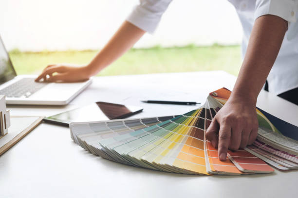 istock interior design or graphic designer working on project of architecture drawing with work tools and color swatches, colour chart in digital tablet at workplace 876941004