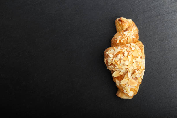 istock croissant on a black background, top view 876941192