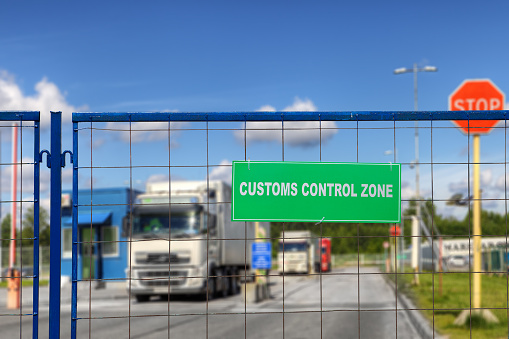 Lorries pass through checkpoint of logistics complex with customs services.