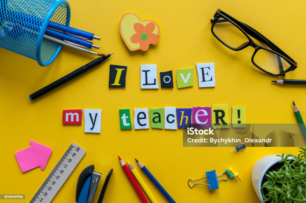 i love my Teacher - text made with carved letters on yellow desk with office or school supplies on pupil table i love my Teacher - text made with carved letters on yellow desk with office or school supplies on pupil table. Teacher Stock Photo