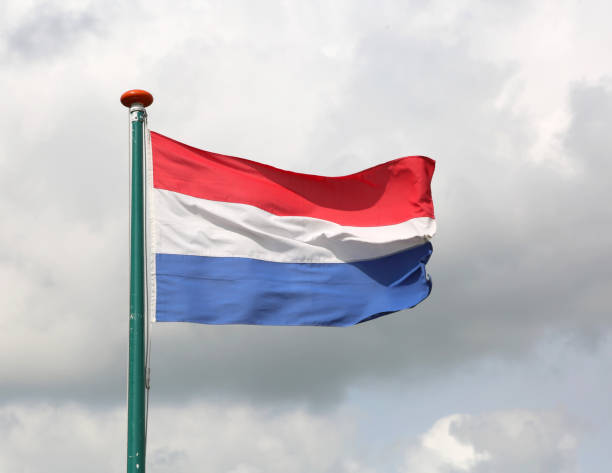 istock waving Dutch flag with white and blue red and cloudy sky 876954192
