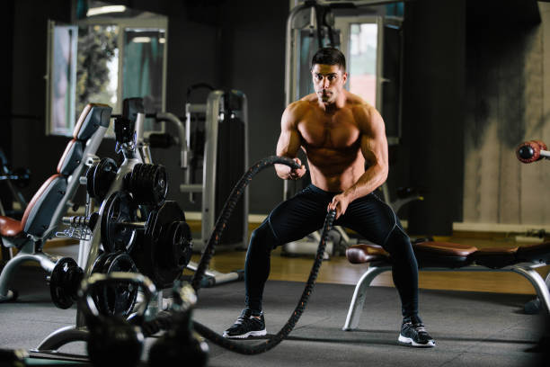 istock Muscular Fit Man Exercising in a Gym 876954374