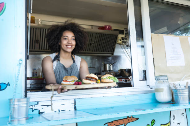 istock Female food van worker giving order to customer 876956710