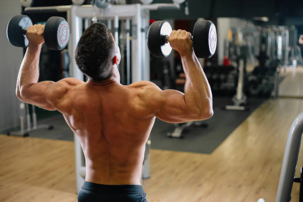 istock Muscular Fit Man Exercising in a Gym 876958034